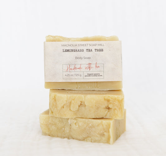 three bars of handmade lemongrass tea tree soap stacked with white cloth background.