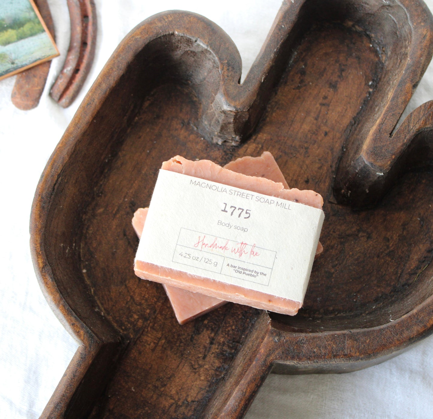 Bar of 1775 handmade soap stacked inside wooden saguaro dough bowl. 