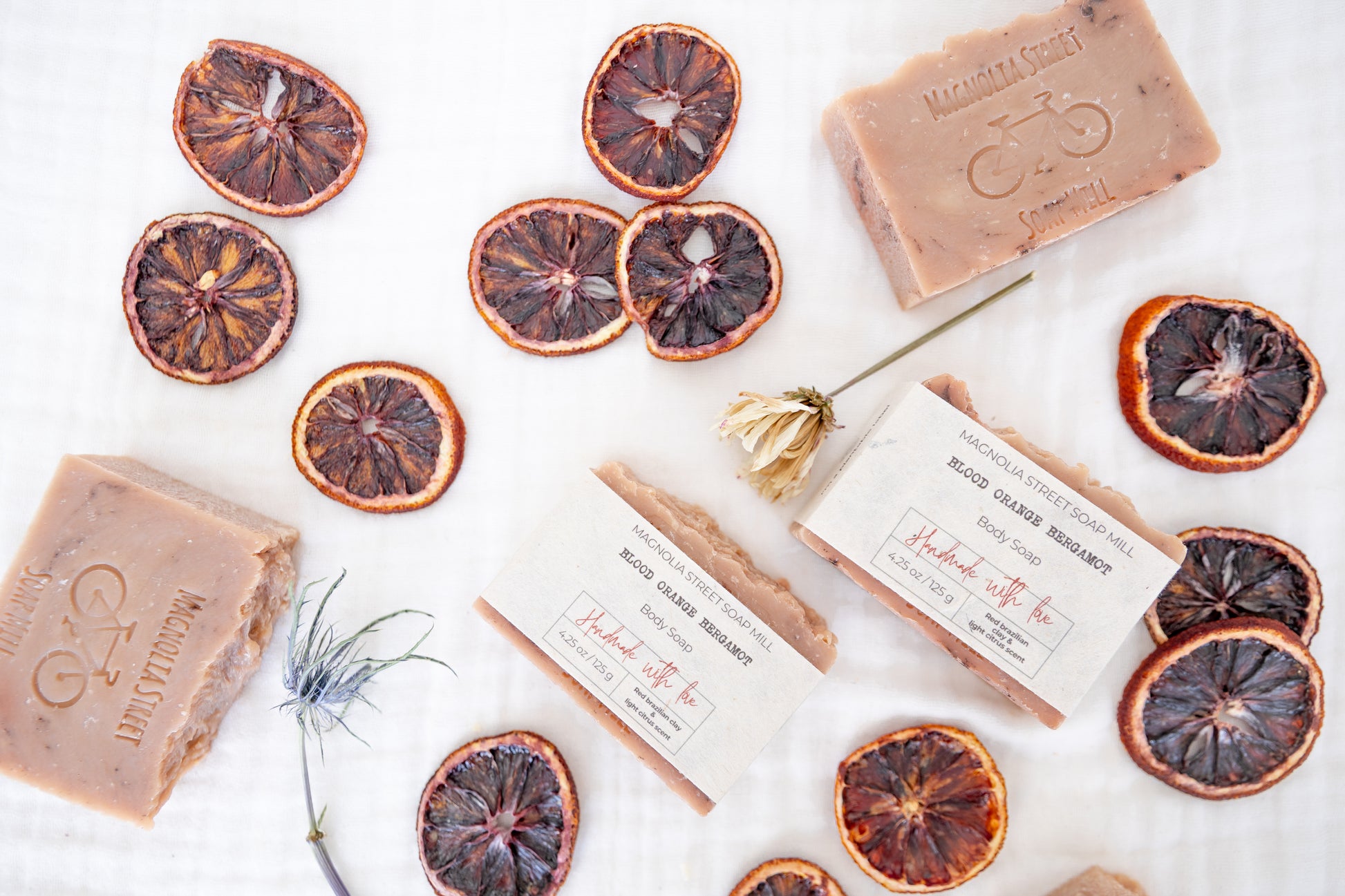Natural Blood Orange Bergamot Bar soaps with dried orange slices and florals on a white background