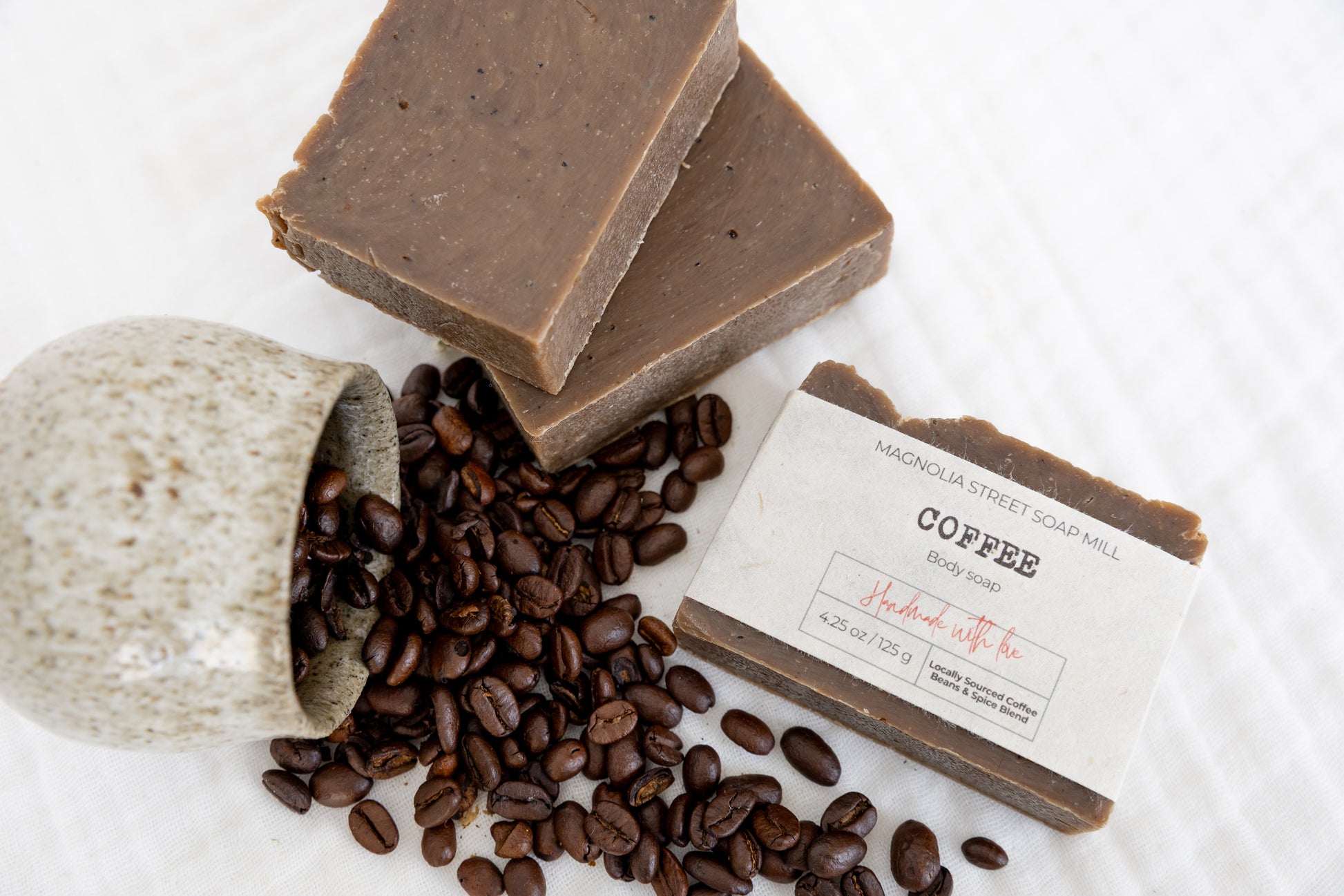 Coffee-themed soap with coffee beans and a label on a white background