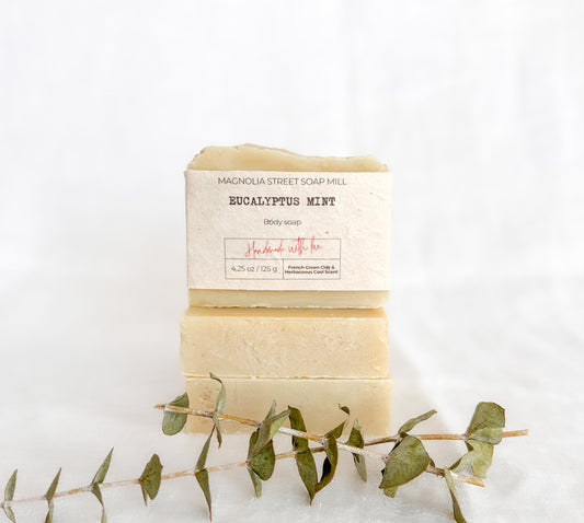 handmade bar of soap with a eucalyptus leaf on a white background