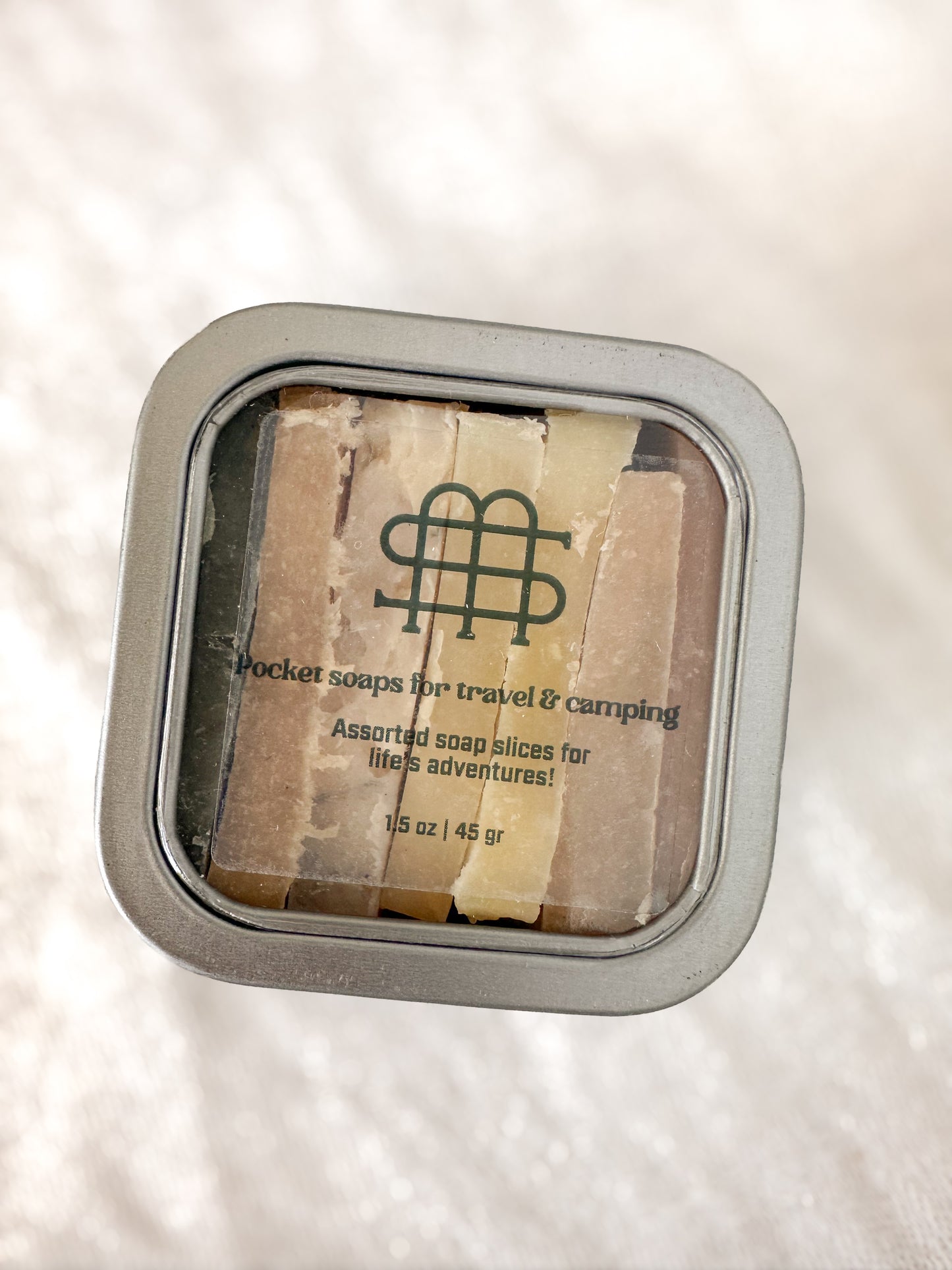 Set of pocket soaps for travel and camping in a metal tin with label.