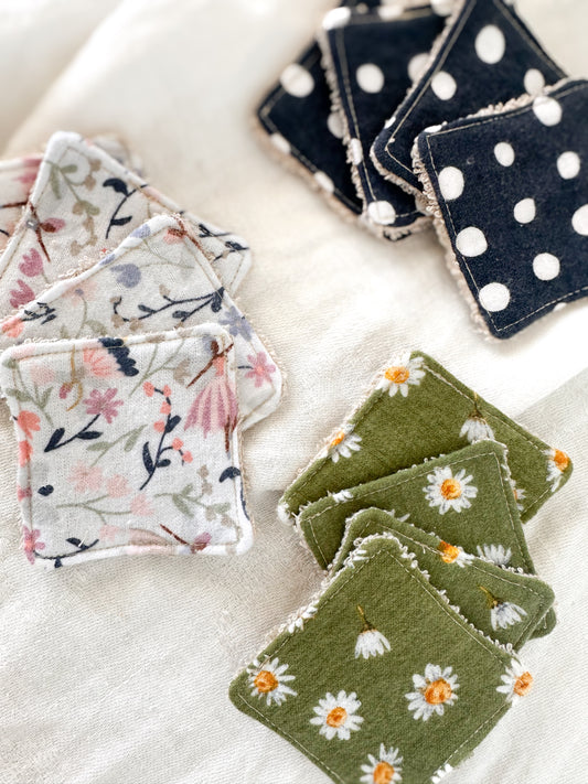 Set of reusable cotton squares with floral, polka dot, and nature-themed designs on a light background.
