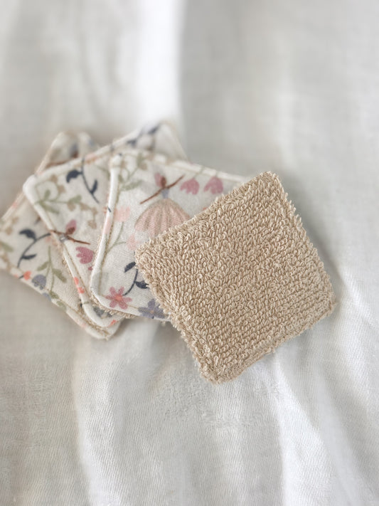 Set of reusable cotton squares with floral patterns on a white surface